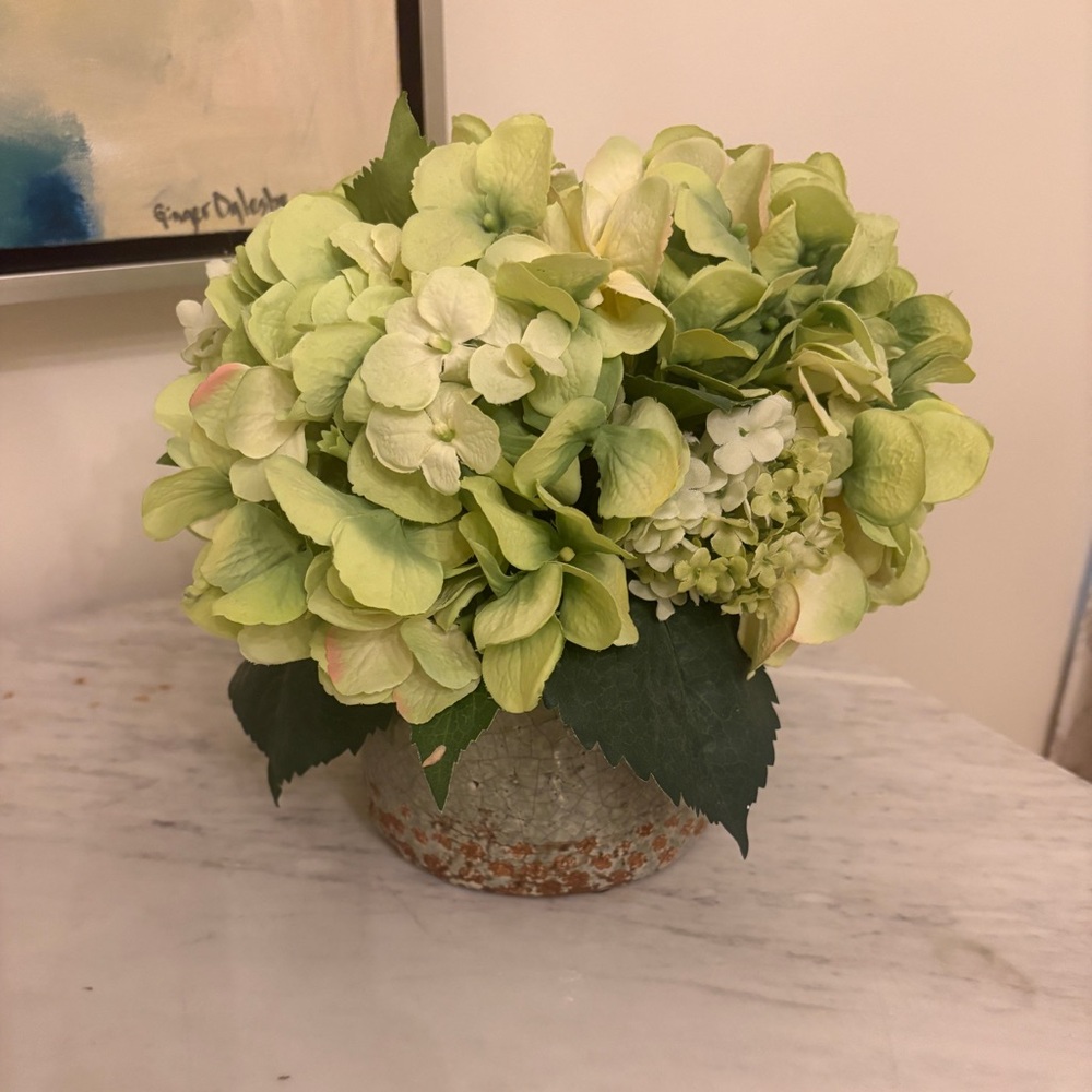 Faux floral arrangement in rustic pottery vase